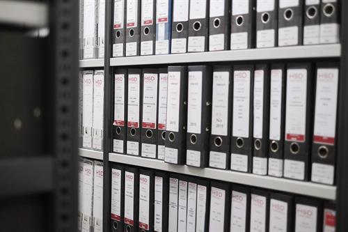 Foto: Nahaufnahme Regal mit Aktenordnern zur Archivierung